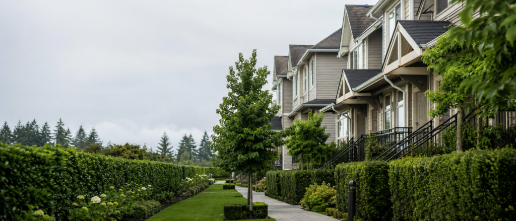 Modern suburban homes with manicured hedges and landscaped gardens in Surrey BC, representing professional strata property management services